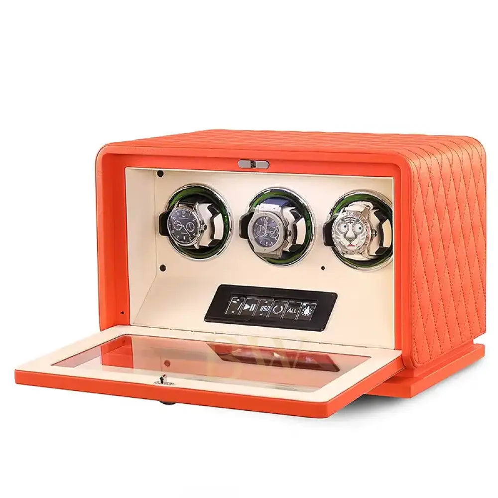 Orange watch winder with three watches on a white background