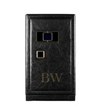 Black leather watch winder safe with gold accents on a white background