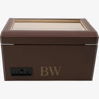Brown leather jewelry box with a glass lid on a white background