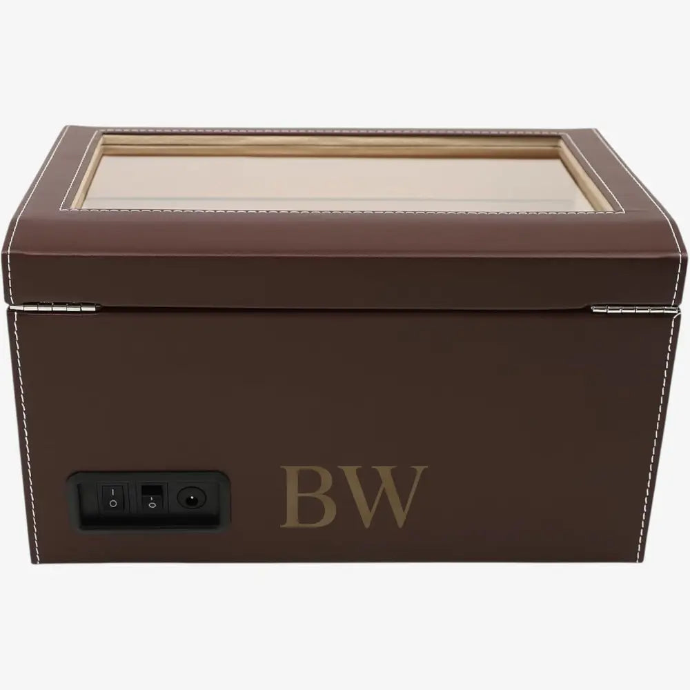 Brown leather jewelry box with a glass lid on a white background