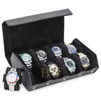 A black watch roll box with 8 cushioned slots holding multiple luxury watches, plus one watch displayed on a small matching stand in front.