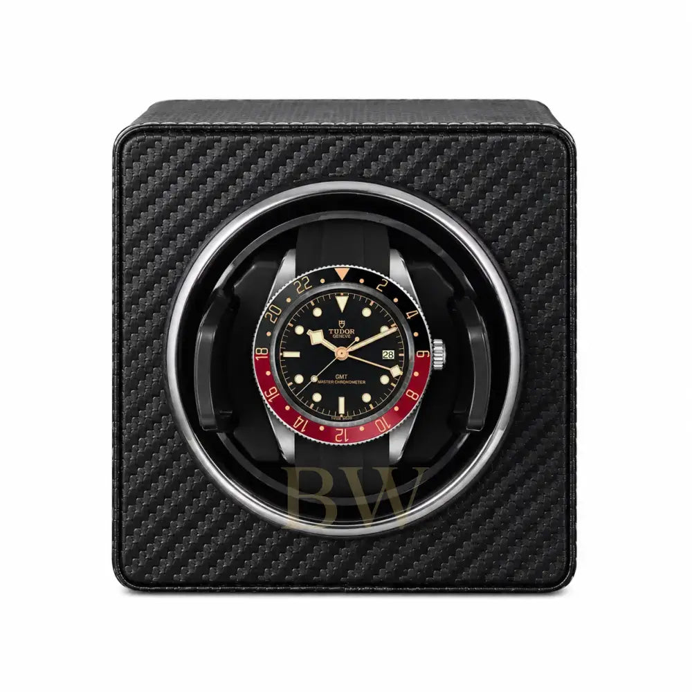 Tudor watch in a black carbon fiber watch winder on a white background