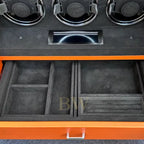 Jewelry storage compartments with black interior and orange exterior, featuring compartments and a handle.