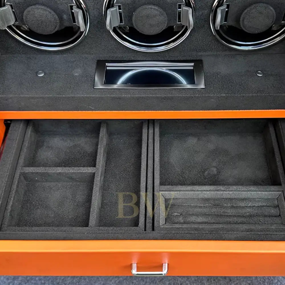 Jewelry storage compartments with black interior and orange exterior, featuring compartments and a handle.