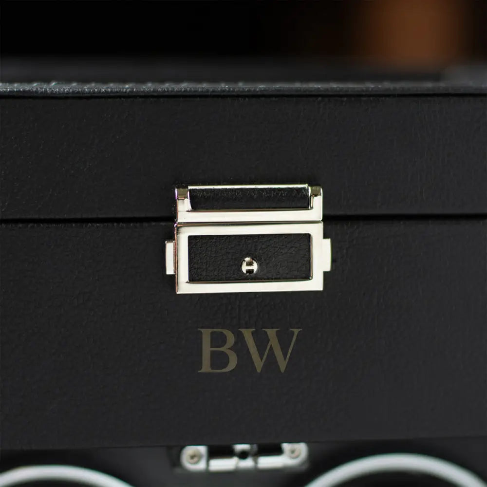 Close-up of a black leather suitcase with a gold clasp.