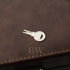 Silver key-shaped bottle opener on a brown leather surface