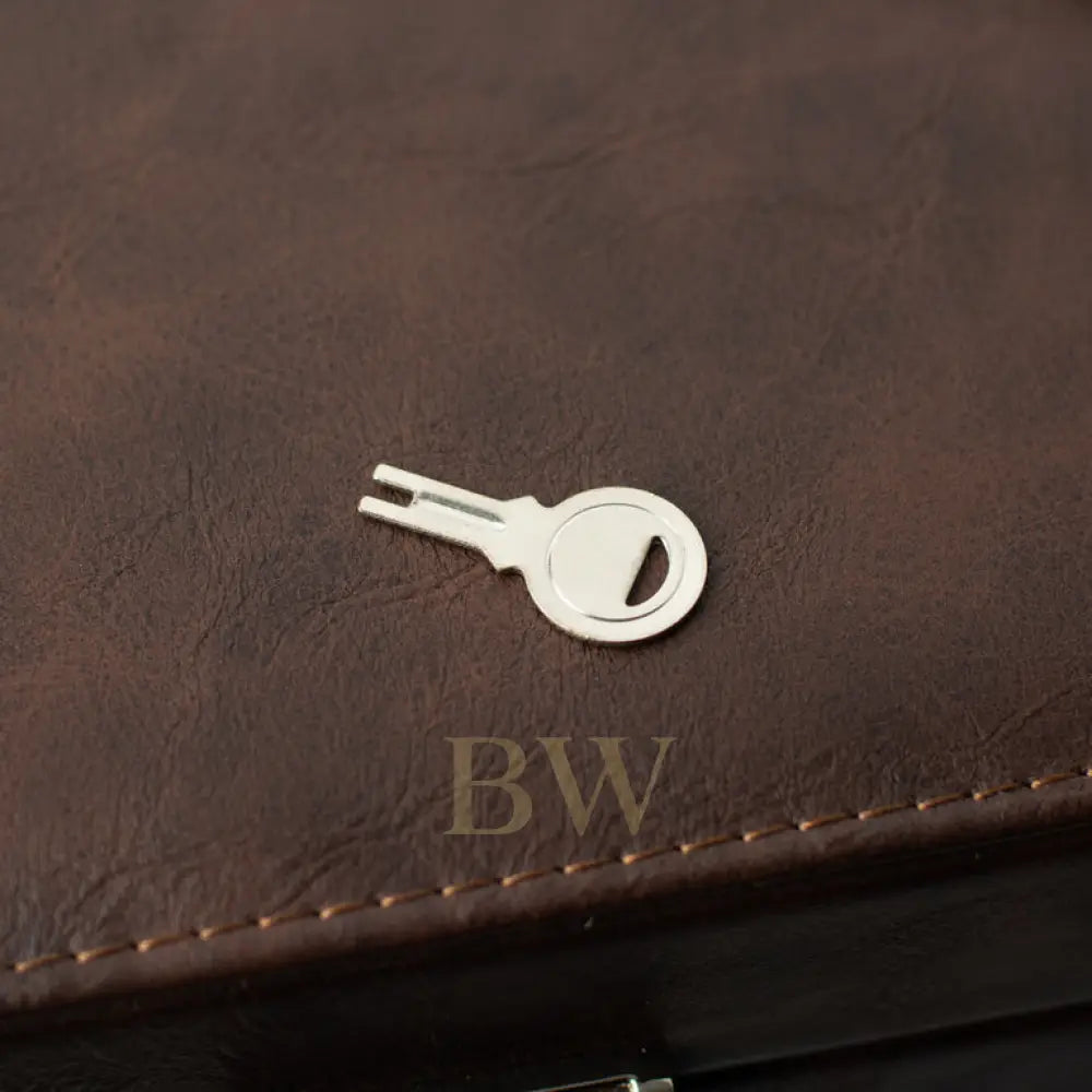 Silver key-shaped bottle opener on a brown leather surface