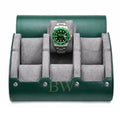 A green leather watch roll stand with a gray velvet interior, shown open and holding a Rolex Hulk watch with a green dial and bezel.