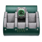 A green leather watch roll stand with a gray velvet interior, shown open and holding a Rolex Hulk watch with a green dial and bezel.