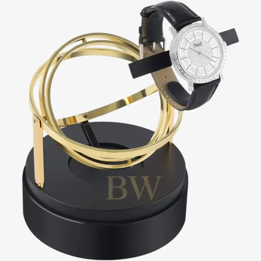 Luxury watch stand with gold loops and a black watch winder on a white background