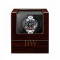 Rolex GMT Master in a wooden vitage watch winder case with a white background