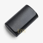 A black textured leather cylindrical watch roll 