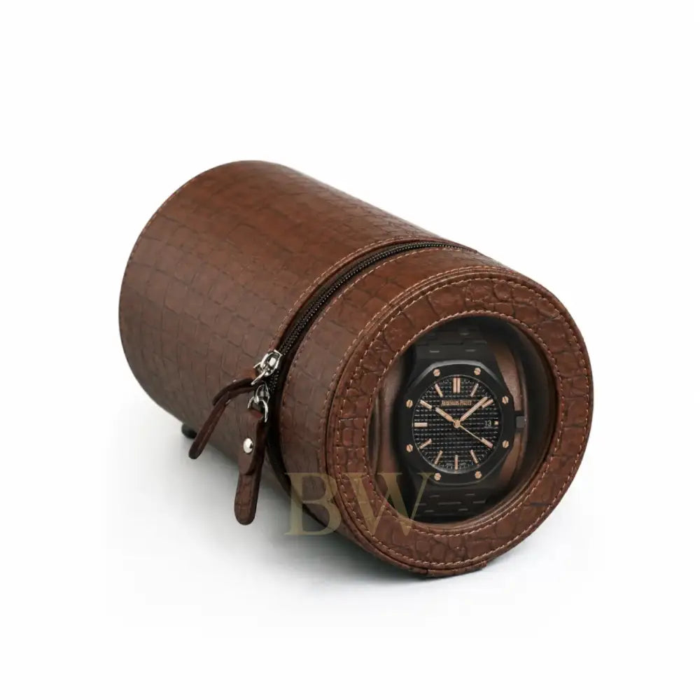 Brown crocodile-rounded watch winder with a black Audemars luxury watch inside