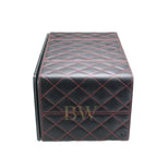 Black quilted leather watch winder side mat with red stitching on a white background