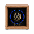 Rolex Daytona watch in a black watch winder case within a wooden box on a white background
