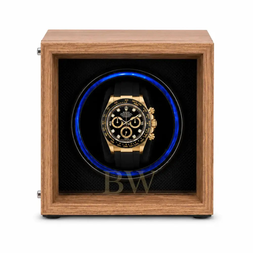 Rolex Daytona watch in a black watch winder case within a wooden box on a white background