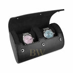 A black leather watch roll with an open hinged lid, featuring two cushioned watch slots holding two Rolex watches with pink and light blue dials, set against a plain white background.