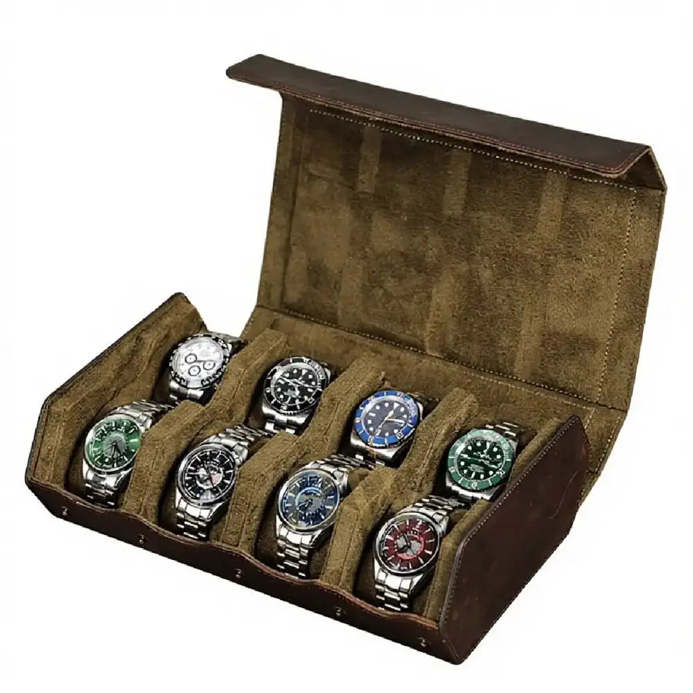 An open brown leather watch storage box with a brown suede-like interior, holding eight watches with silver bracelets and colorful dials.