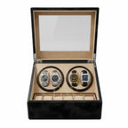 A luxury watch winder box with a black textured exterior and a beige interior, shown open with two watch rotation slots containing two watches. The top lid features a clear glass window, and the bottom section has individual watch slots.