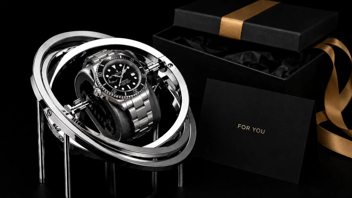Watch winder for gift with open face on a stand next to a gift box with 'For You' card