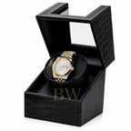Gold and silver Seiko watch in a black crocodile watch winder patterned box on a white background