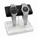 Two silver luxury watches Tudor and Audemars Piguet on a marble watch stand with a white background
