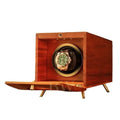 Wooden watch winder with a gold rolex watch inside on a white background