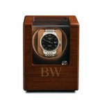 Wooden watch winder with a Tissot watch inside on a white background